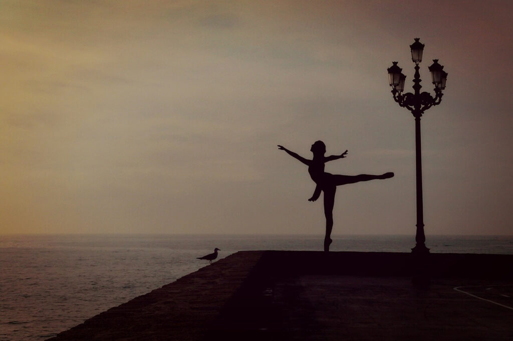 silouette of a dancer at a pier at sunset